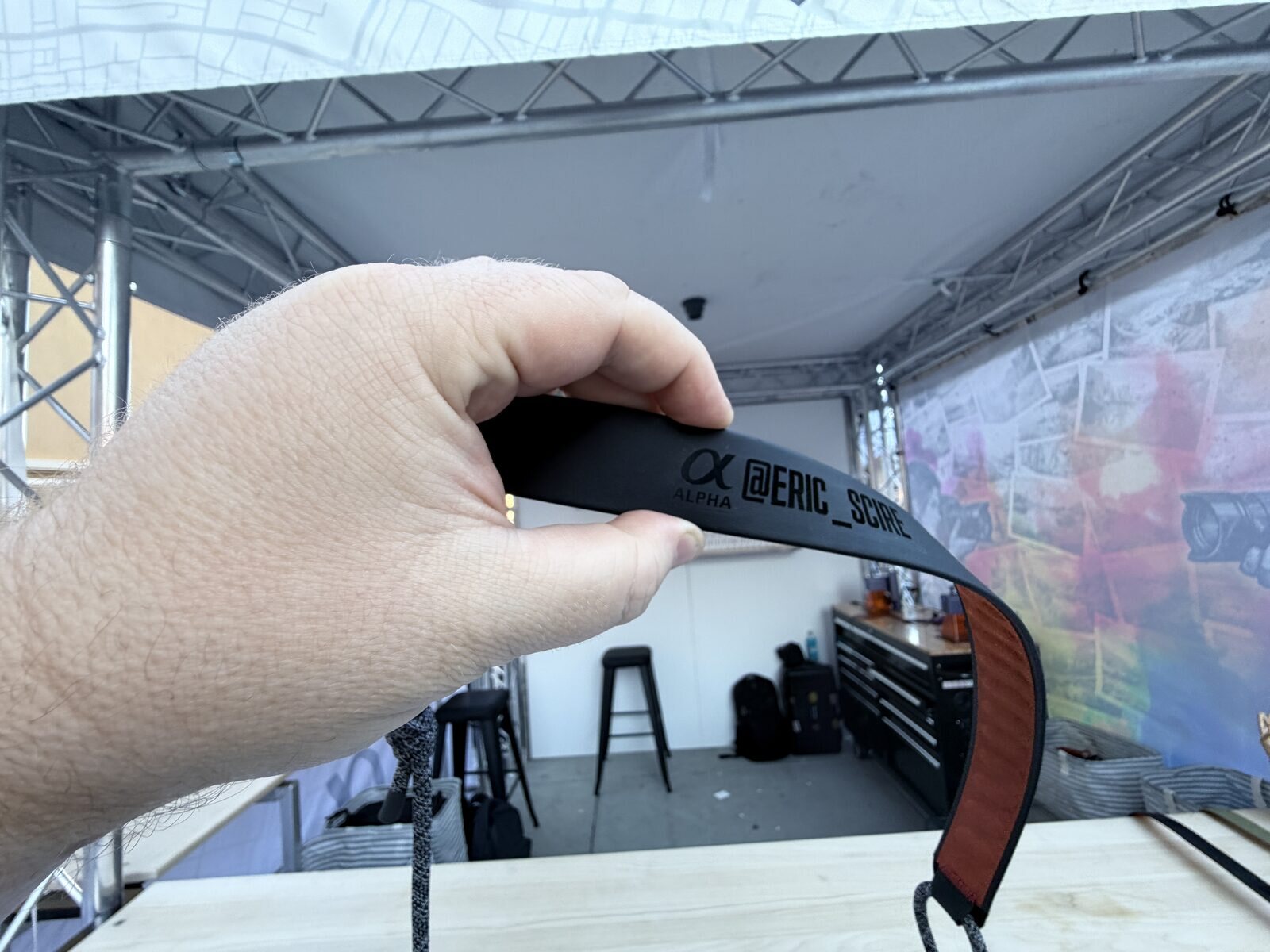 Guest holding a personalized engraved camera strap made at an outdoor festival booth